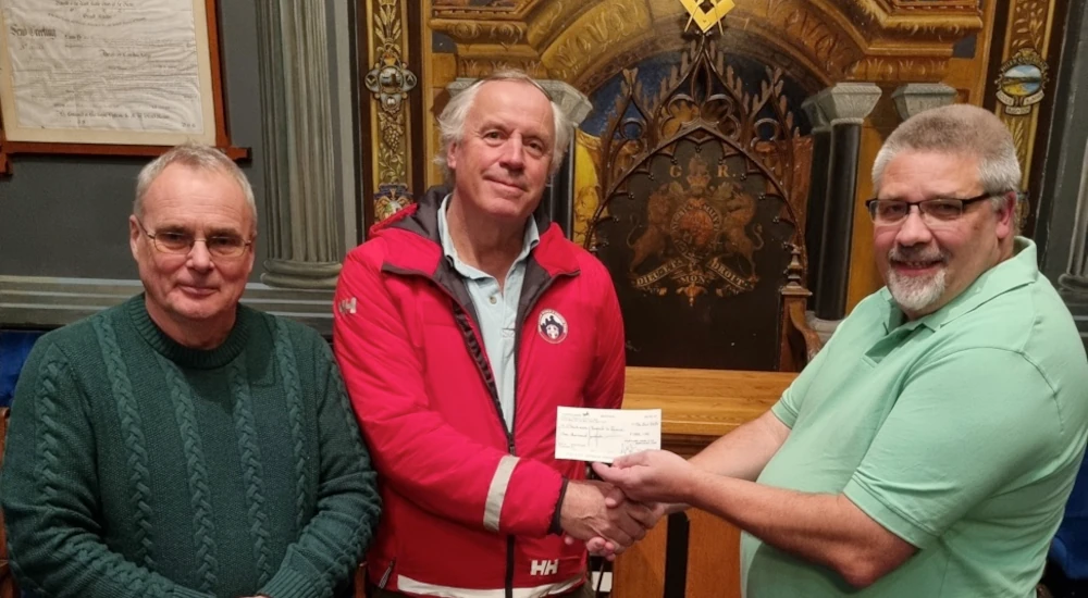Bro Derek Burtenshaw and W. Bro Mike Locke presenting cheque to Alec Collyer of Dartmoor Rescue Group